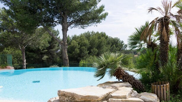 A swimming pool surrounded by trees and a stone wall. - T2 1 bedroom 4 people for rent 83700 Saint Raphaël / Le Dramont  (Saint-Raphaël)