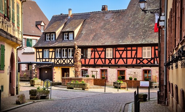 A traditional half-timbered building with a courtyard, stone planters, and a street lamp.