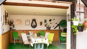 A dining area with a table, chairs, and a green floor. - Homerez - Apartment in Kientzheim (Kientzheim)