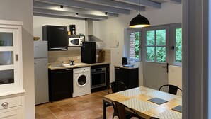 A compact kitchen with a washing machine, a microwave, and a coffee maker.