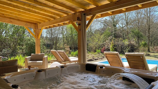 A hot tub area with wooden loungers and a covered pergola.
