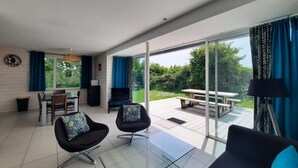 Una sala de estar moderna con una mesa de centro de vidrio, un sofá y un comedor con mesa y sillas.