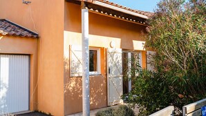A building with a tiled roof, a satellite dish, and a door with a window.