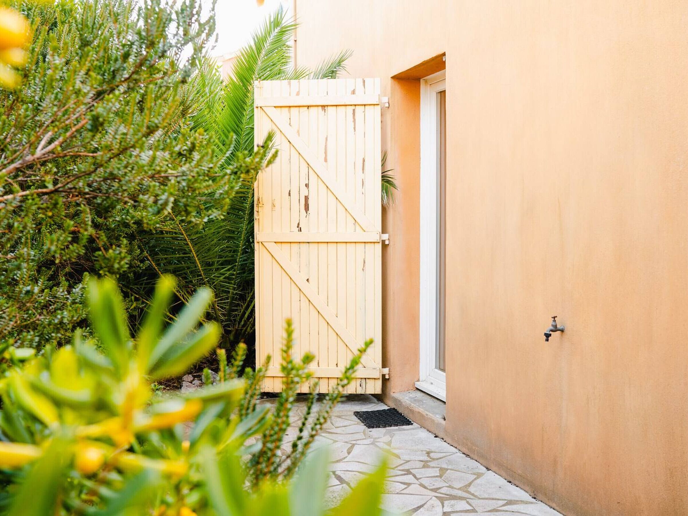 Een houten poort die leidt naar een gebouw met een betegelde ingang.