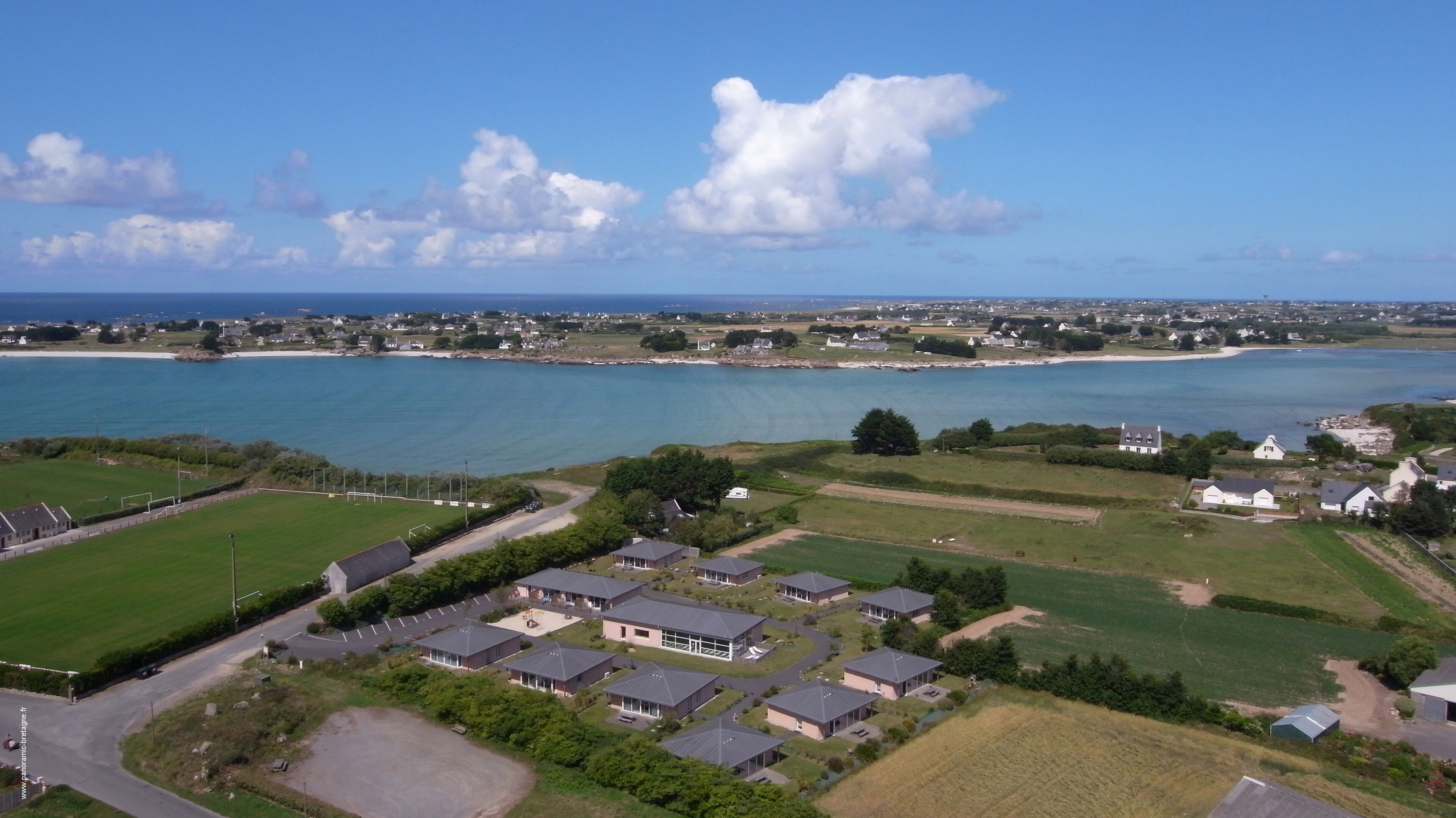 Una zona residenziale sul lungomare, con case, spiaggia e cielo sereno.