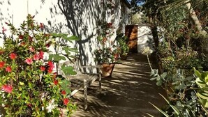 A garden pathway with a bench and potted plants. - Studio & large garden 200m Calvi beach (Calvi)