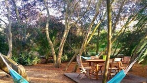 A hammock, wooden deck, and outdoor furniture in a wooded area. - Studio & large garden 200m Calvi beach (Calvi)