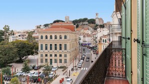 Une vue urbaine mettant en évidence un bâtiment imposant, avec un toit rouge et un clocher en arrière-plan.