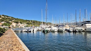 Ein Yachthafen mit Booten, die an einer gepflasterten Promenade festgemacht sind.