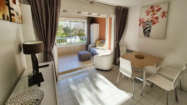 Een moderne kamer met balkon, een eethoek en een bed.