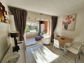 A modern room with a balcony, a dining area, and a bed. - 150 m beach, private domain with swimming pool (SIX FOURS LES PLAGES)