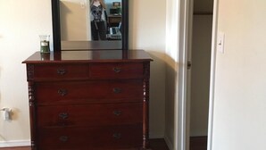 Un aparador de madera con cajones en una habitación, con un espejo encima.