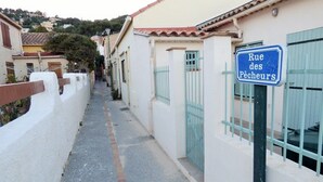 A narrow street with a sign reading "Rue des Pêcheurs" and a building with a white facade and blue shutters. - Beachfront, Comfortable, AIR CONDITIONER (ST MANDRIER SUR MER)