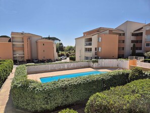 A residential building with a swimming pool surrounded by neatly trimmed hedges. - Swimming pool, balcony, facing south, sleeps 4. (LA SEYNE SUR MER)