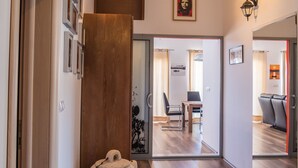 A hallway with wooden flooring, a stone sculpture, and a modern interior design with a dining area visible through a glass door. - PENTHOUSE with SPECTACULAR SEA VIEW (Hvar)