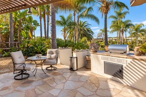 An outdoor patio with a stone floor, a grill station, and seating. - Rancho Santa Fe Covenant Detached Guest House (Rancho Santa Fe)