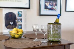 A table with a green patterned container holding a champagne bottle, two empty wine glasses, and a bowl of lemons. - Rancho Santa Fe Covenant Detached Guest House (Rancho Santa Fe)