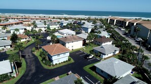 Un quartier résidentiel situé sur la côte, avec des maisons, un parking et une vue sur l’océan.