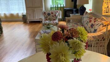 A room with a floral arrangement on a table, a sofa, and a cabinet.