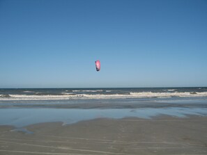 A beach with a kite surfer in the air. - Best location in all of Jax Beach. Walk or bike ride to everything. (Jacksonville Beach)