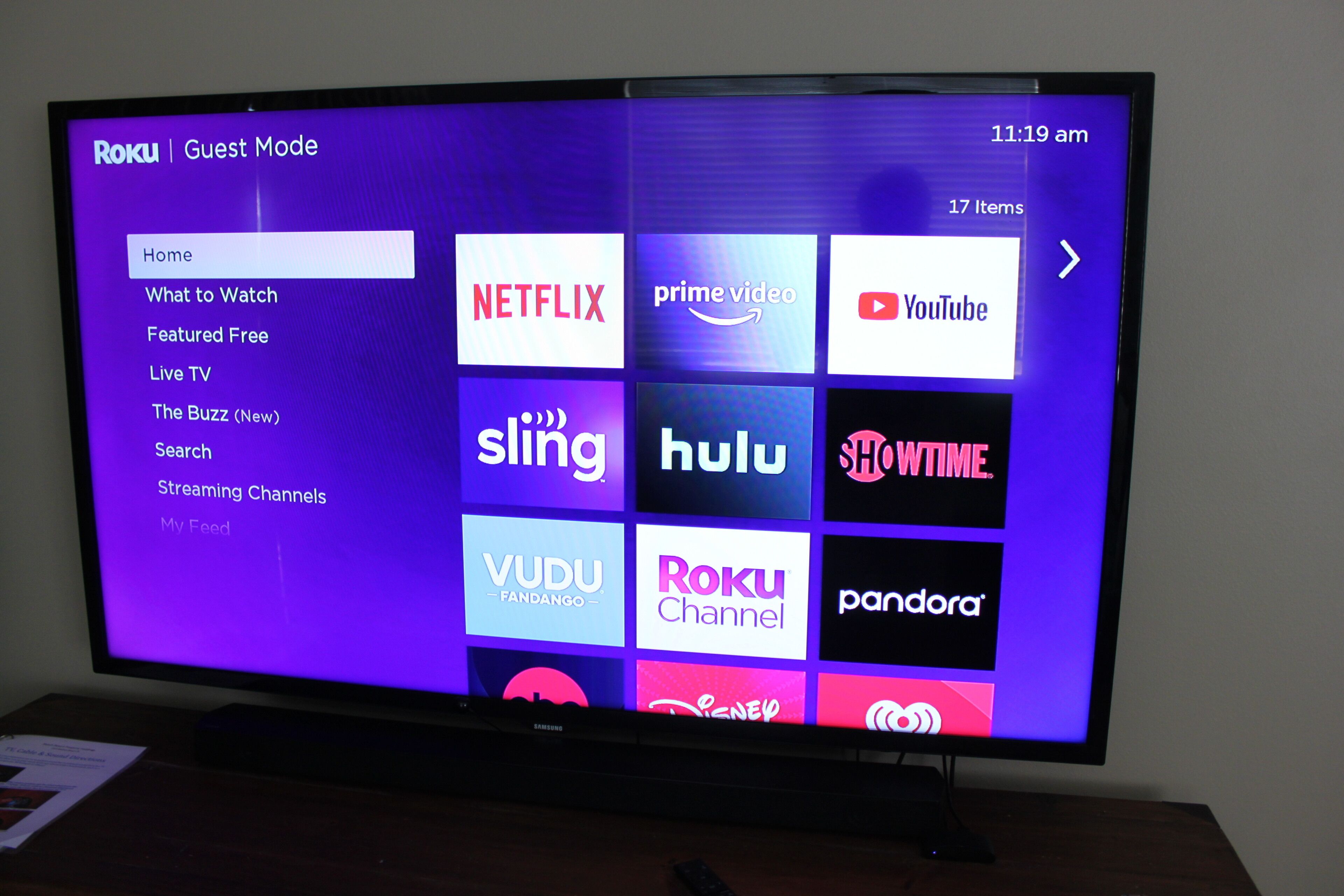 Televisor de pantalla plana que muestra la interfaz de Roku y varios logotipos de servicios de transmisión.