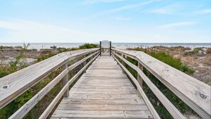 A wooden boardwalk leading to a gate, surrounded by beach vegetation. - Largest 1BR/1BA in IOP | Pool | Pet Friendly (Isle of Palms)