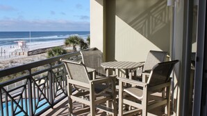 A balcony with a view of the beach and ocean.
