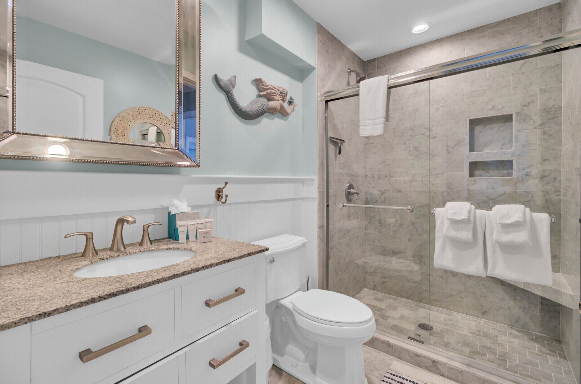 Une salle de bain avec deux lavabos, des toilettes et une douche à l’italienne.