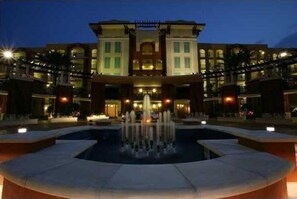 Stunning hotel facade with a central entrance, flanked by two wings, and a beautiful fountain in the foreground.