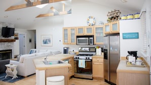 Una cocina moderna con armarios de madera, microondas, refrigerador y estufa a gas.