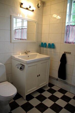 Een bad/douchecombinatie, handdoeken