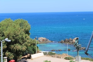 A coastal view with a clear sky, rocky shoreline, and a statue. - Ranias luxurious Apartment with sea view! (Chania)