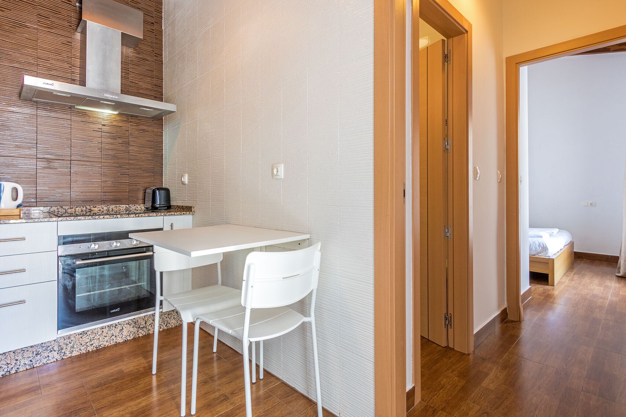 A compact kitchen with a white countertop, a built-in oven, and a coffee maker.