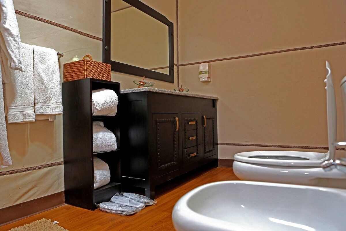 Une salle de bain avec un meuble-lavabo en bois, un miroir, un lavabo et des toilettes.
