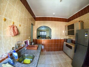 Réfrigérateur, un four, surface de cuisson, vaisselle et ustensiles