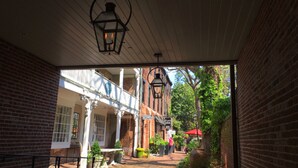 An outdoor corridor with brick walls, a covered area with a wooden ceiling, and hanging lanterns. - Duvall House - George Washington ate here! In the heart of Old Town Alexandria.  (Alexandria)