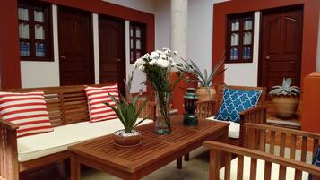 A cozy seating area with a wooden table, chairs, and a sofa with striped pillows.