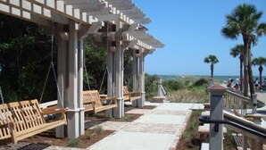 A covered outdoor seating area with benches and a pergola structure. - ~BEAUTIFUL HOME NESTLED IN THE PERFECT TOWN~ (Bluffton)