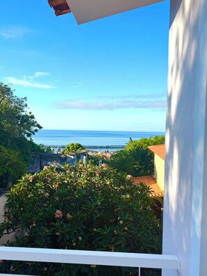 En balkon med havudsigt og en bygning med et tag af teglsten.