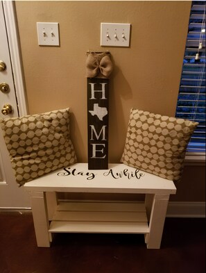 A bench with a sign that reads "HOME Stay Awhile" and a Texas state outline. - Central, Airport & Downtown: Hotel House Retreat (San Antonio)