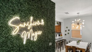 A modern kitchen with a neon sign reading "Sunshine & Magic" on a green wall. - Park all day, recharge in style- 10min to Disney, clean, revamped w/ resort pool (Kissimmee)