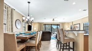 Un comedor con una mesa y sillas de madera, un candelabro y vistas al exterior.