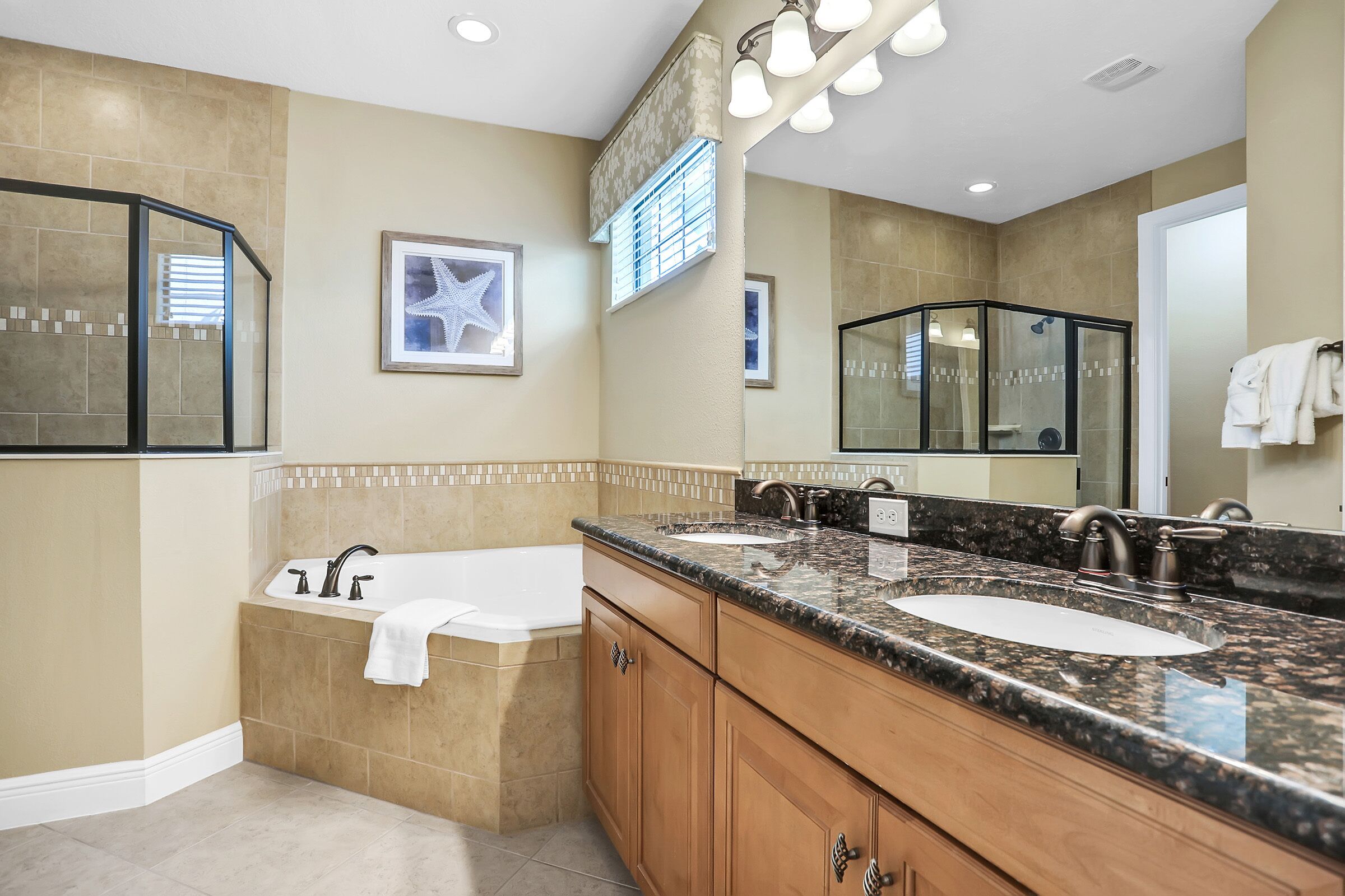 A modern bathroom with a freestanding bathtub, two sinks, and a large mirror.