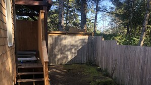 A wooden deck with a built-in bench and a small outdoor seating area.