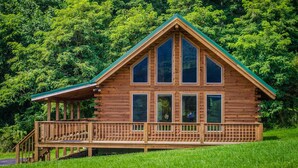 A wooden cabin with a green roof, large windows, and a wooden deck. - ✧Queen Cabin - wait until you see the BATHROOM! (Dryfork)