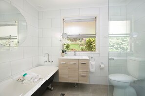 A modern bathroom with a bathtub, sink, and toilet.