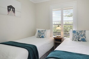 A room with two beds, a window with blinds, a lamp on a bedside table, and a picture on the wall. - Dogs Stay Free. Cosy Restful Retreat with Fireplace. (Wentworth Falls)