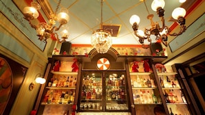 A bar with a chandelier, shelves of liquor bottles, and a decorative ceiling. - "Modern cozy renovated apartment is waiting for you in the heart of Athens.  (Athina)