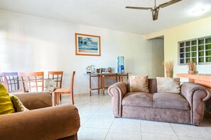 A living room with a sofa, chairs, a coffee table, and a ceiling fan. - 129Nght Sep/Oct Cozumel 2 Bdrs Villa Beach/OceanFront Snorkeling Diving Paradise (Cozumel)