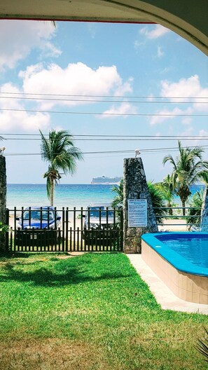 A view of a swimming pool, a wooden fence, and a signboard. - 129Nght Sep/Oct Cozumel 2 Bdrs Villa Beach/OceanFront Snorkeling Diving Paradise (Cozumel)